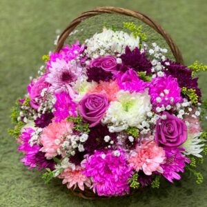 Basket of natural purple roses, chrysanthemums, dahlias, and baby's breath